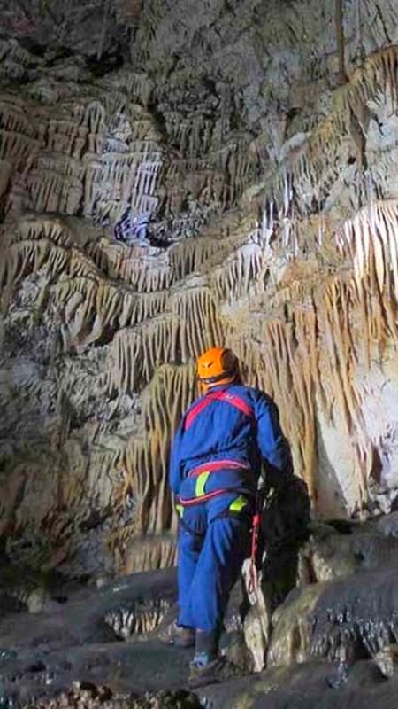 Group of people with helmets and headlamps exploring a natural cave in Venta del Moro.