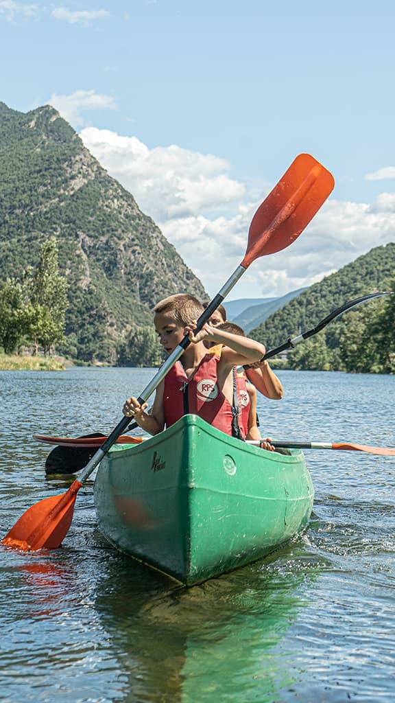 Group of people enjoying a rented canoe ride on the calm waters of La Torrassa Lake.